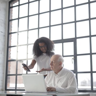 Multiracial businesspeople of different ages using gadgets while working together in creative workplace